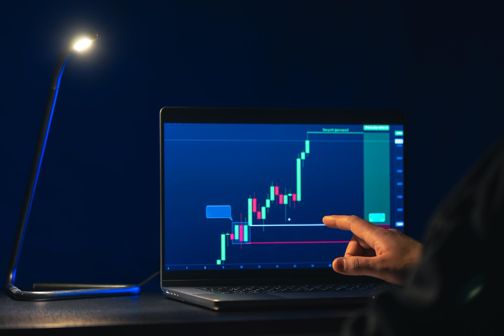 How to Do Forex Fundamental Analysis using economic data and market trends, shown by a trader analysing a forex price chart on a laptop screen.